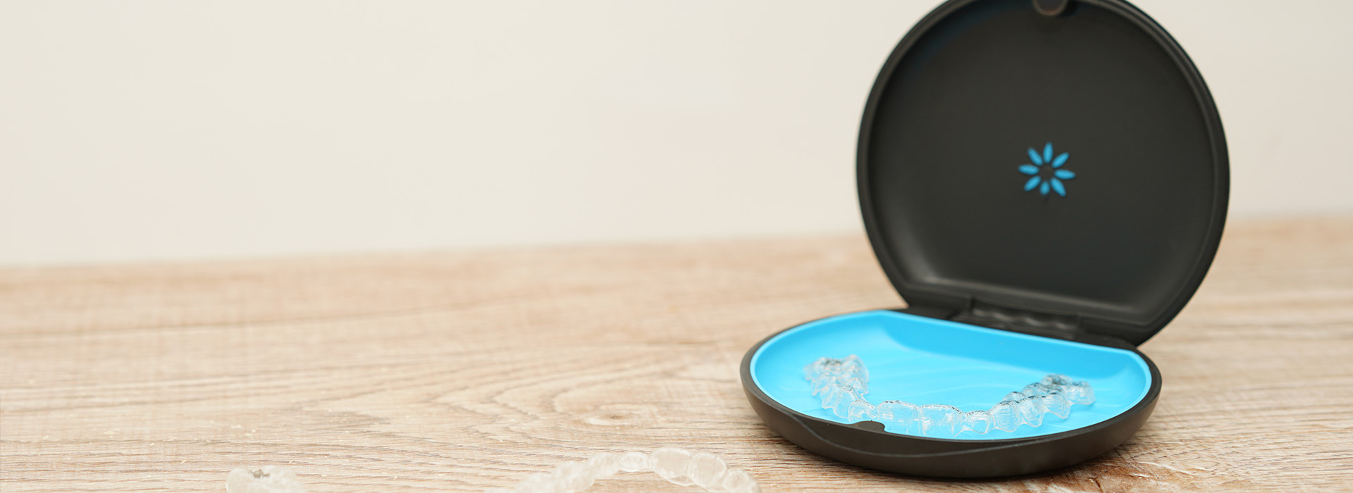 A black smartphone case with a blue circular design on a wooden surface.