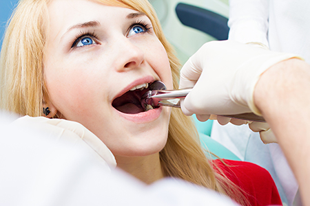 A young woman undergoing dental treatment with a dentist in a professional setting.