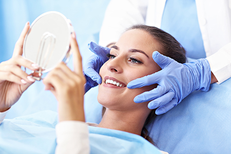 The image shows a woman lying on a bed with a mirror above her head, while a person takes a photo of her face from a lower angle.